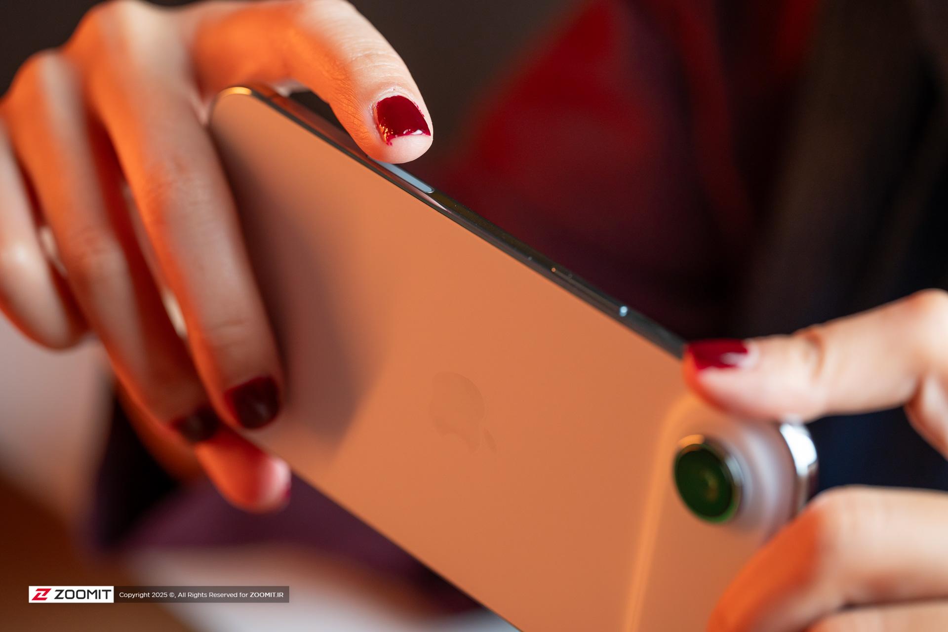 نمای نزدیک از انگشتان یک زن با لاک قرمز که لبه بالایی آیفون ایر را نگه داشته