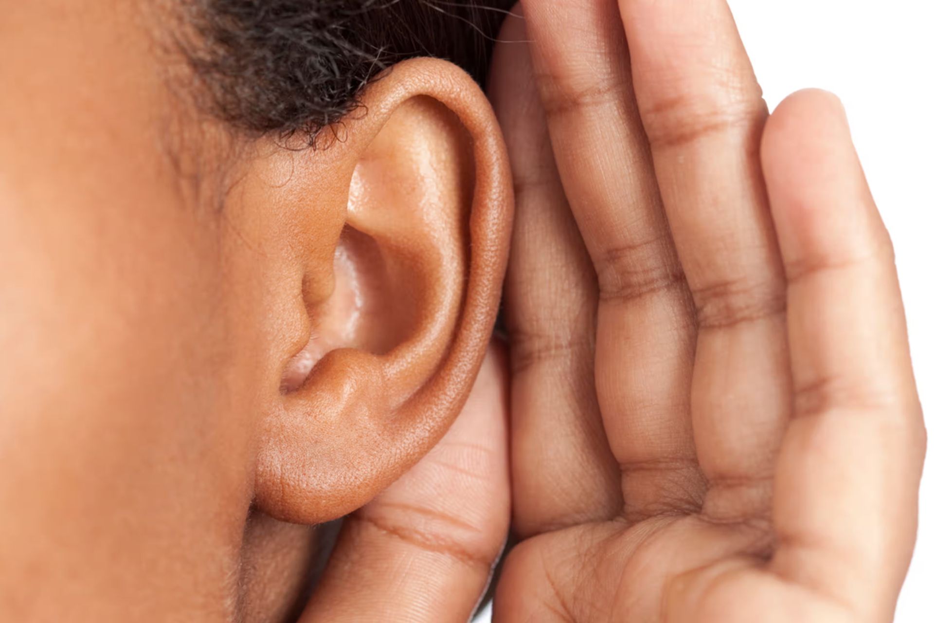 نمای نزدیک از گوش فردی که دستش را پشت گوش قرار داده