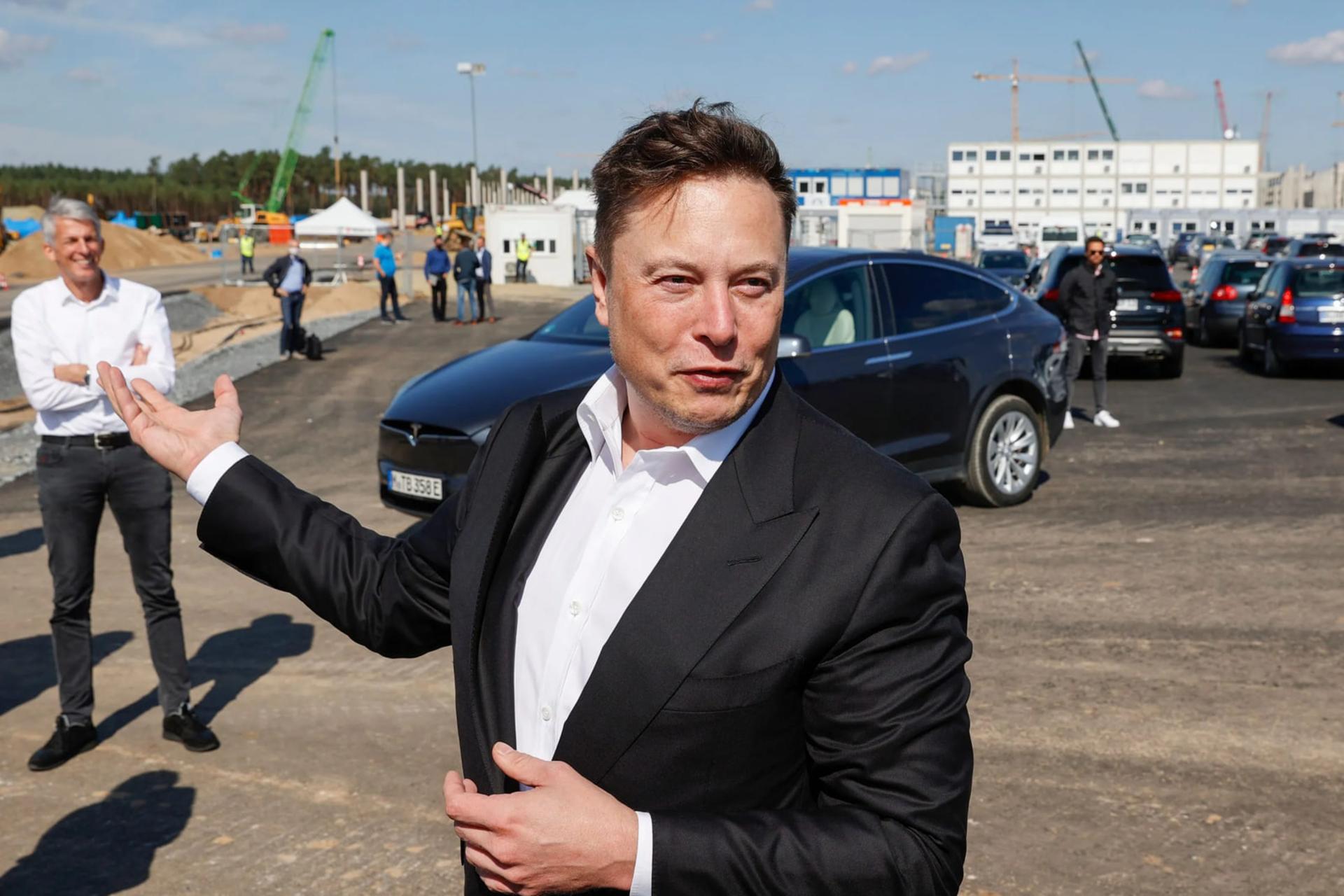 ایلان ماسک (Elon Musk) در کنار خودروی تسلا و سایت ساختمانی پروژه xAI
