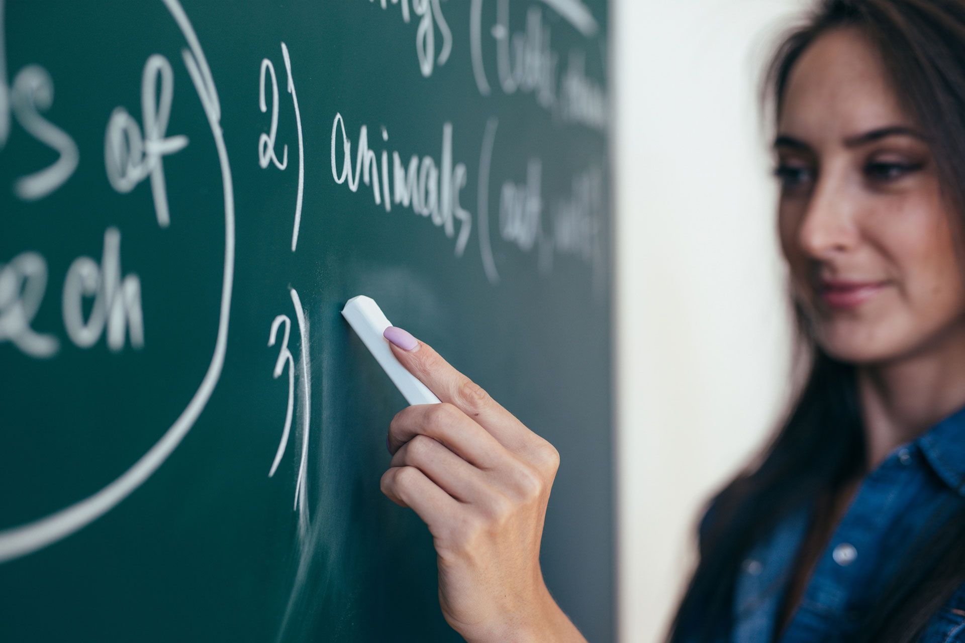 زنی در حال نوشتن انگلیسی با گچ روی تخته سیاه