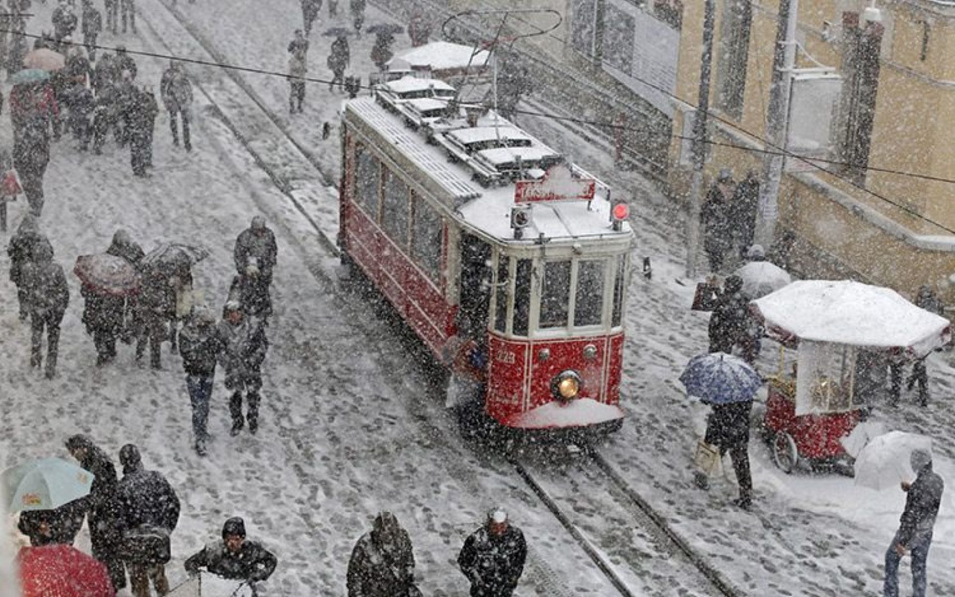 18 people brave the cold and snow as they walk in the main pedestrian street of istiklal in central istanbul s 50b49