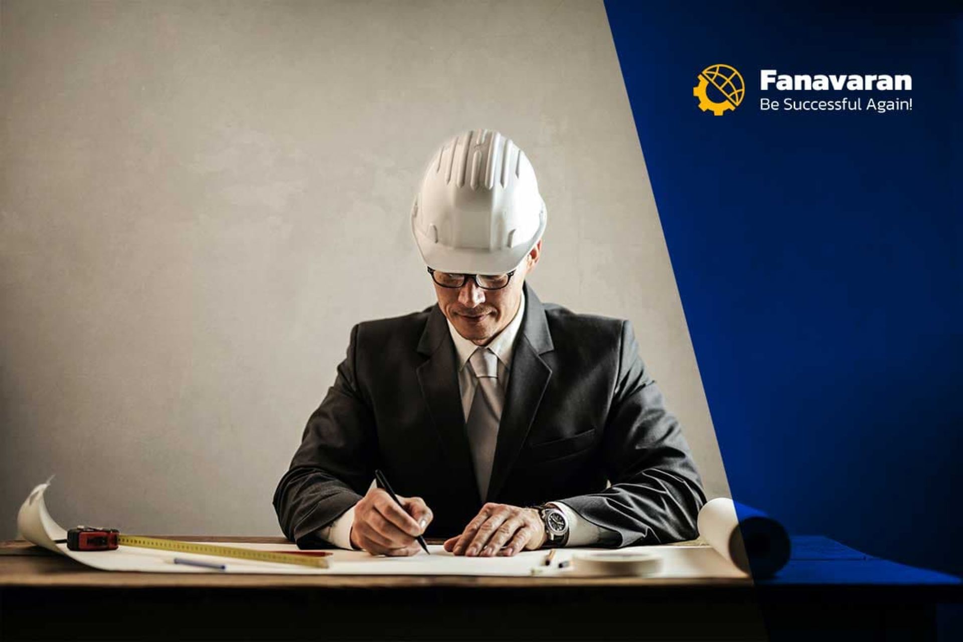 یک مهندس کت شلواری با کلاه ایمنی سفید پشت میز