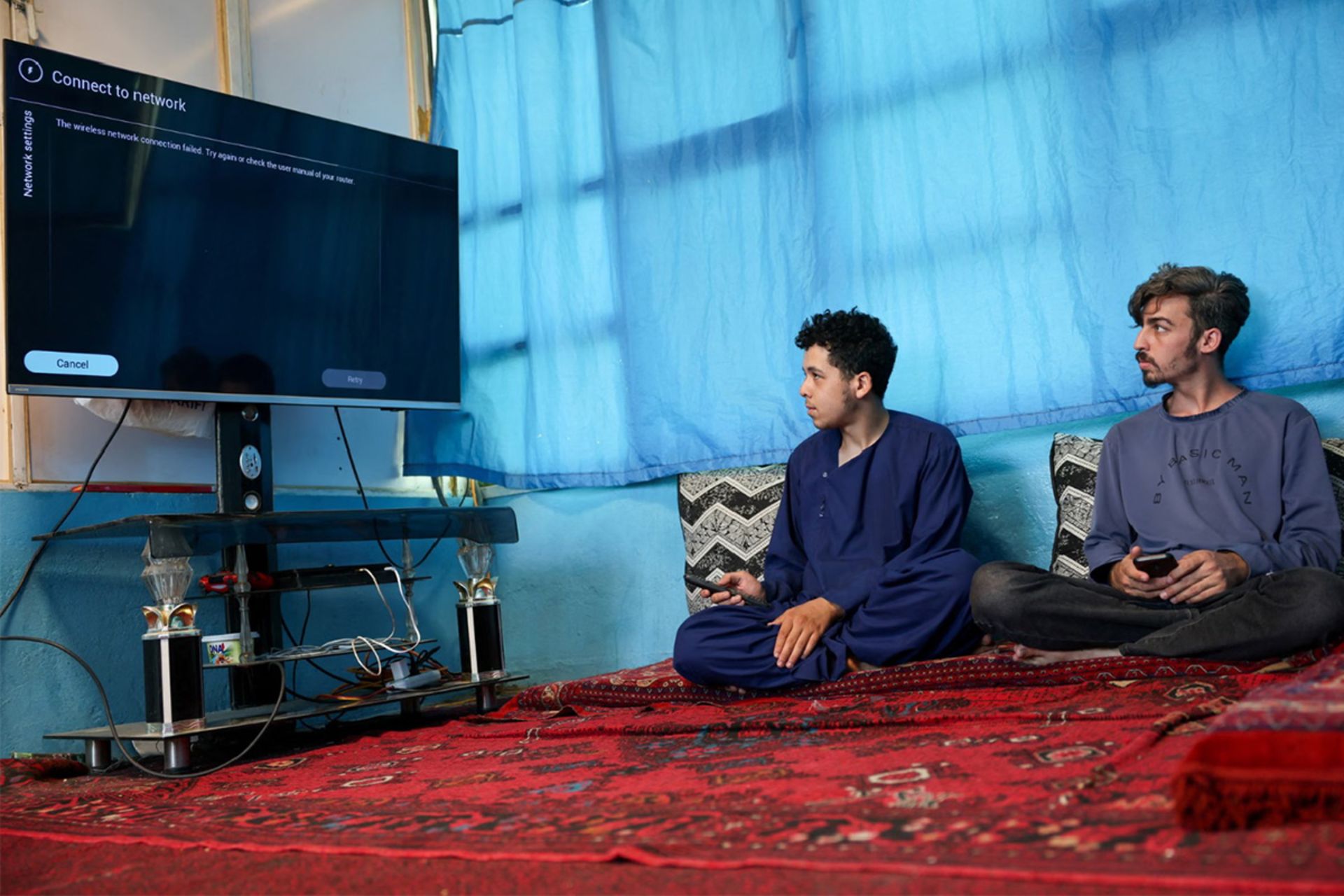 Men trying to connect their smart TV to the internet amid the telecom shutdown in Kabul. Photograph: 