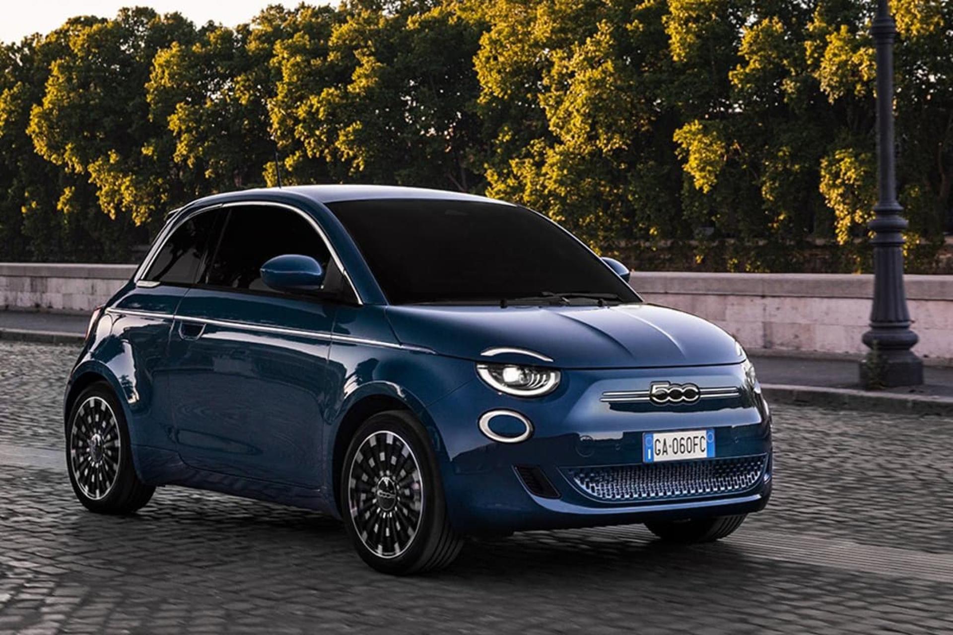 خودروی برقی فیات 500e مدل ۲۰۲۴ آبی با پس‌زمینه‌ی درخت و سنگفرش