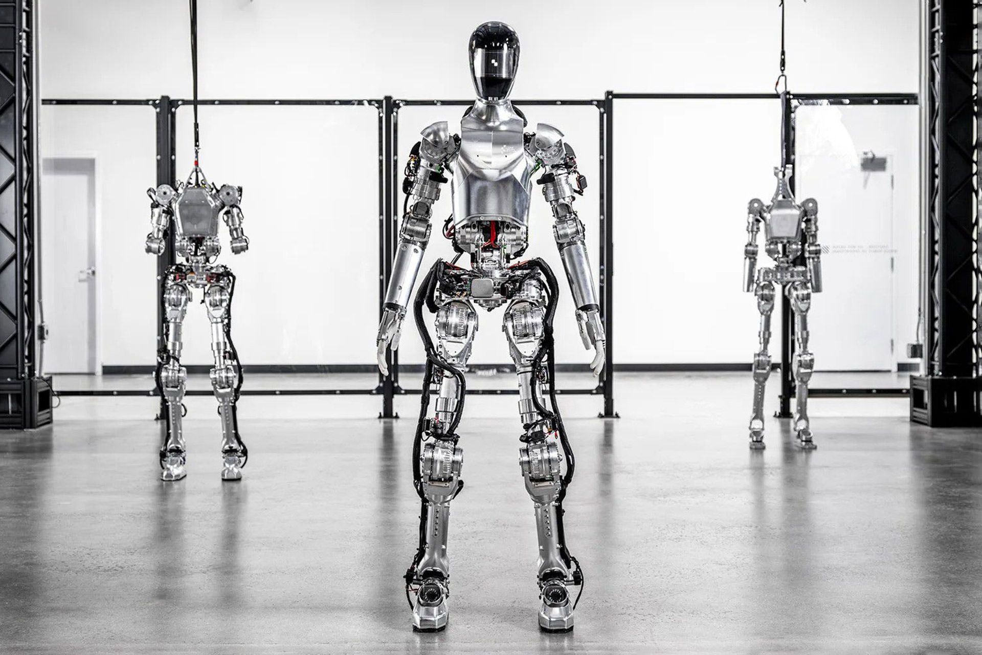 سه ربات انسان‌نمای شرکت فیگور در از نمای جلو - یکی از آن‌ها جلوتر از همه در وسط ایستاده است و دوتای دیگر با فاصله‌ی زیاد در دو سمت آن 