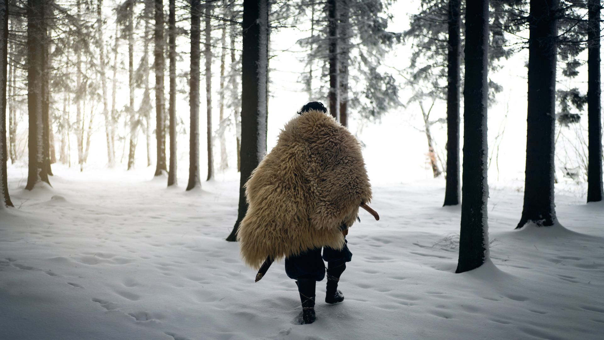 انسان اولیه با پوشش خز در میان جنگل برفی