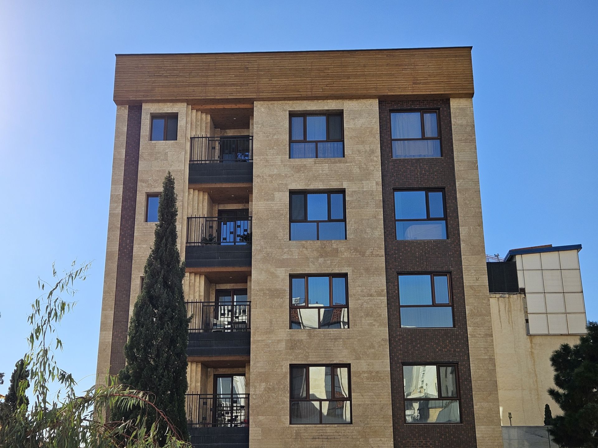 نمای ساختمانی چهار طبقه با رنگ کرمی و قهوه‌ای