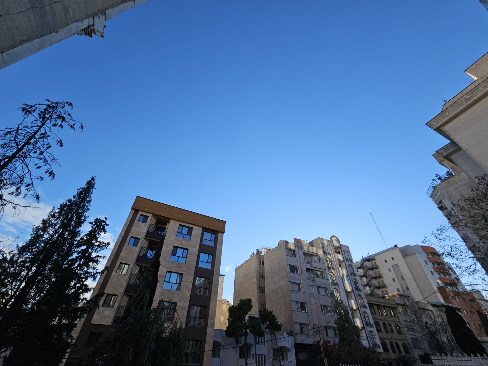 نمونه عکس گرفته شده با دوربین اولتراواید گلکسی S23 پلاس در محیط روشن خارجی از نمای چند ساختمان و آسمان آبی