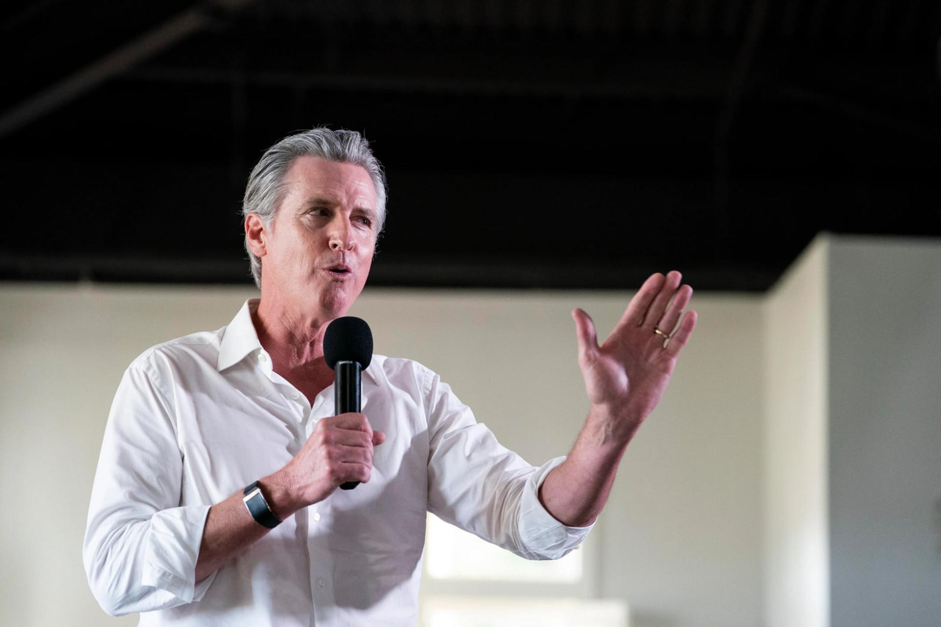 گوینده‌ای با نام گوین نیوسام (Gavin Newsom) در حال صحبت با میکروفون