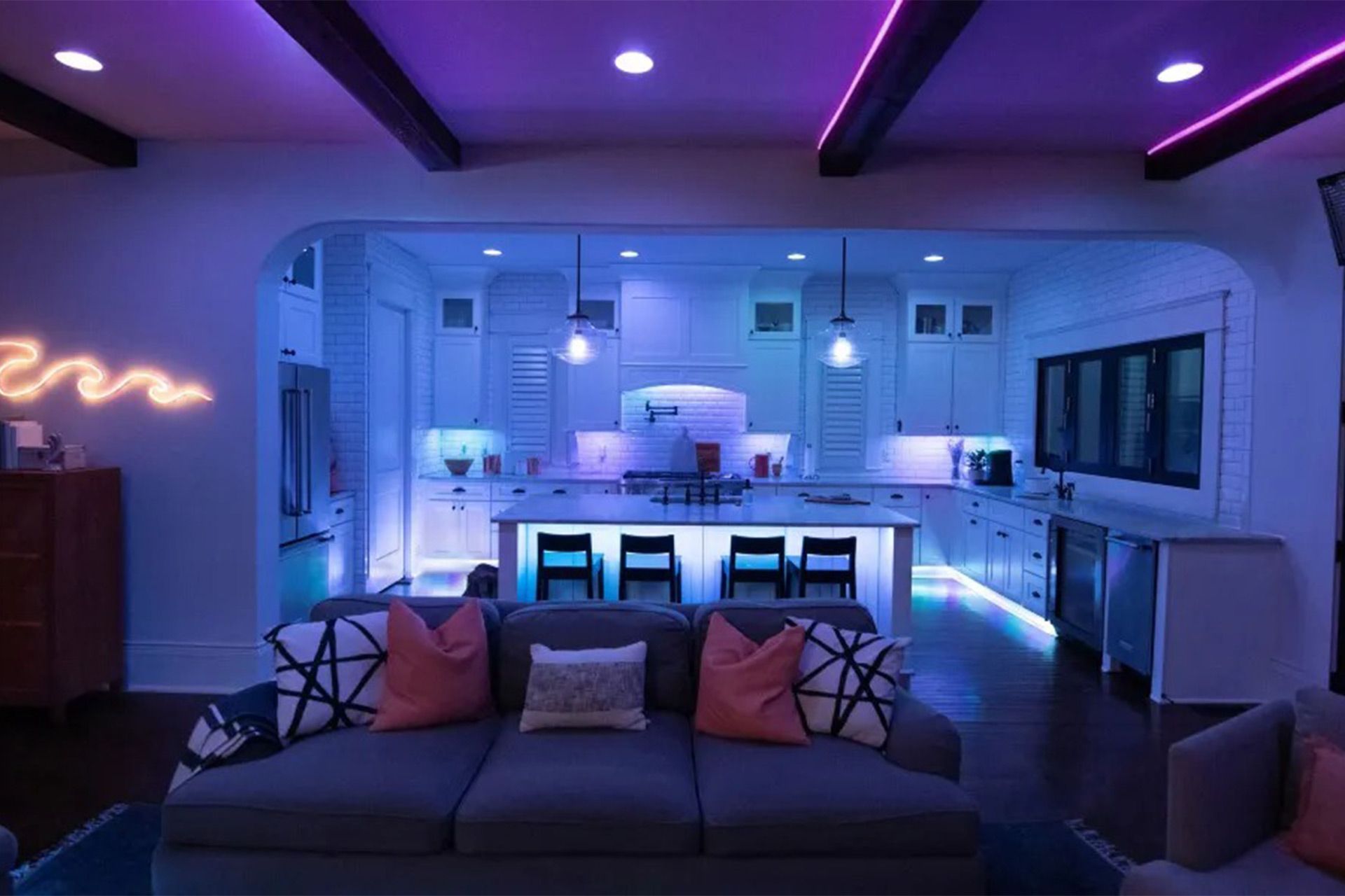 نمایی از آشپزخانه‌ی مدرن با نورپردازی‌های مختلف در زیر کابینت‌ها