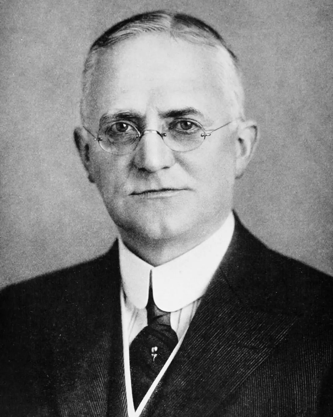 جورج ایستمن (George Eastman) با عینک و کت رسمی
