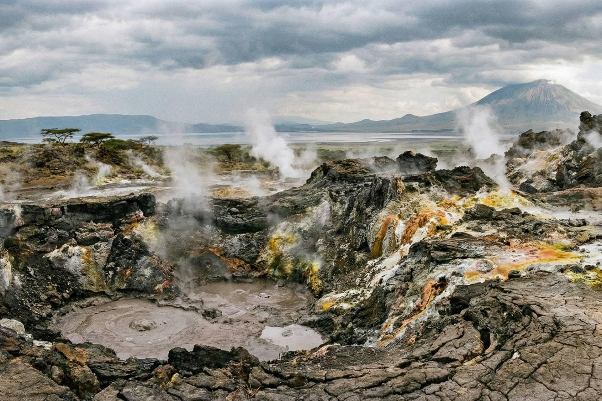 تصویرسازی با زاویه دید باز از یک منظره زمین‌گرمایی، مانند تانزانیا، که در آن بخار از ترک‌های سنگ‌های آتشفشانی باستانی و تیره رنگ بلند می‌شود.