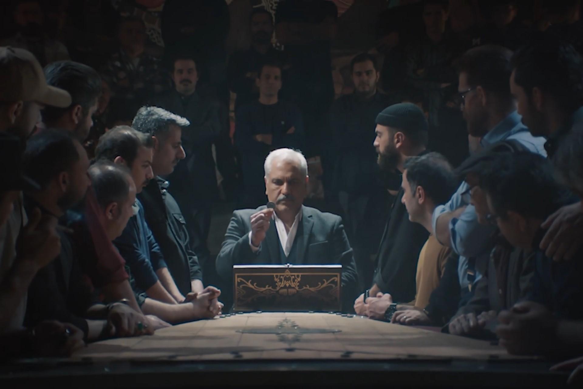 چند نفر دور یک مرد مسن در حال نمایش یک سکه