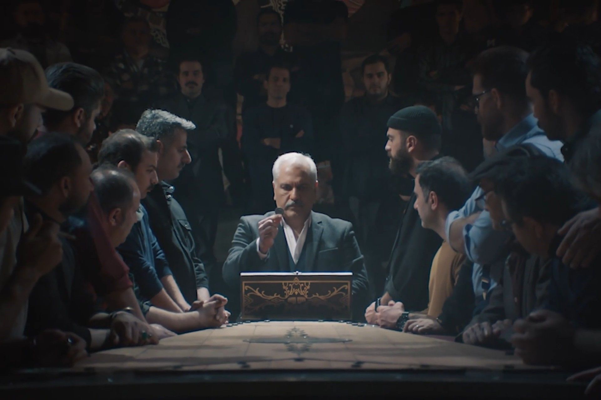 چند نفر دور یک مرد مسن در حال نمایش یک سکه