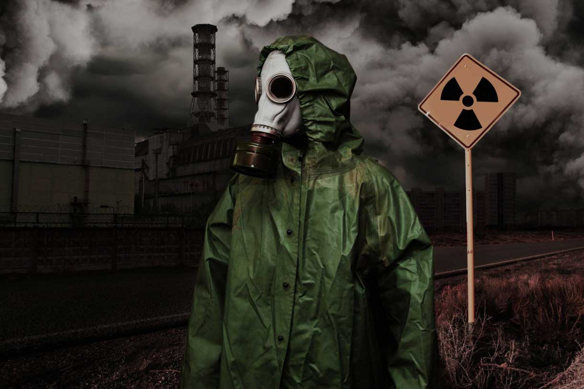 مردی در لباس و ماسک محافظ با پس‌زمینه علامت هشدار هسته‌ای و منظره دود‌آلود