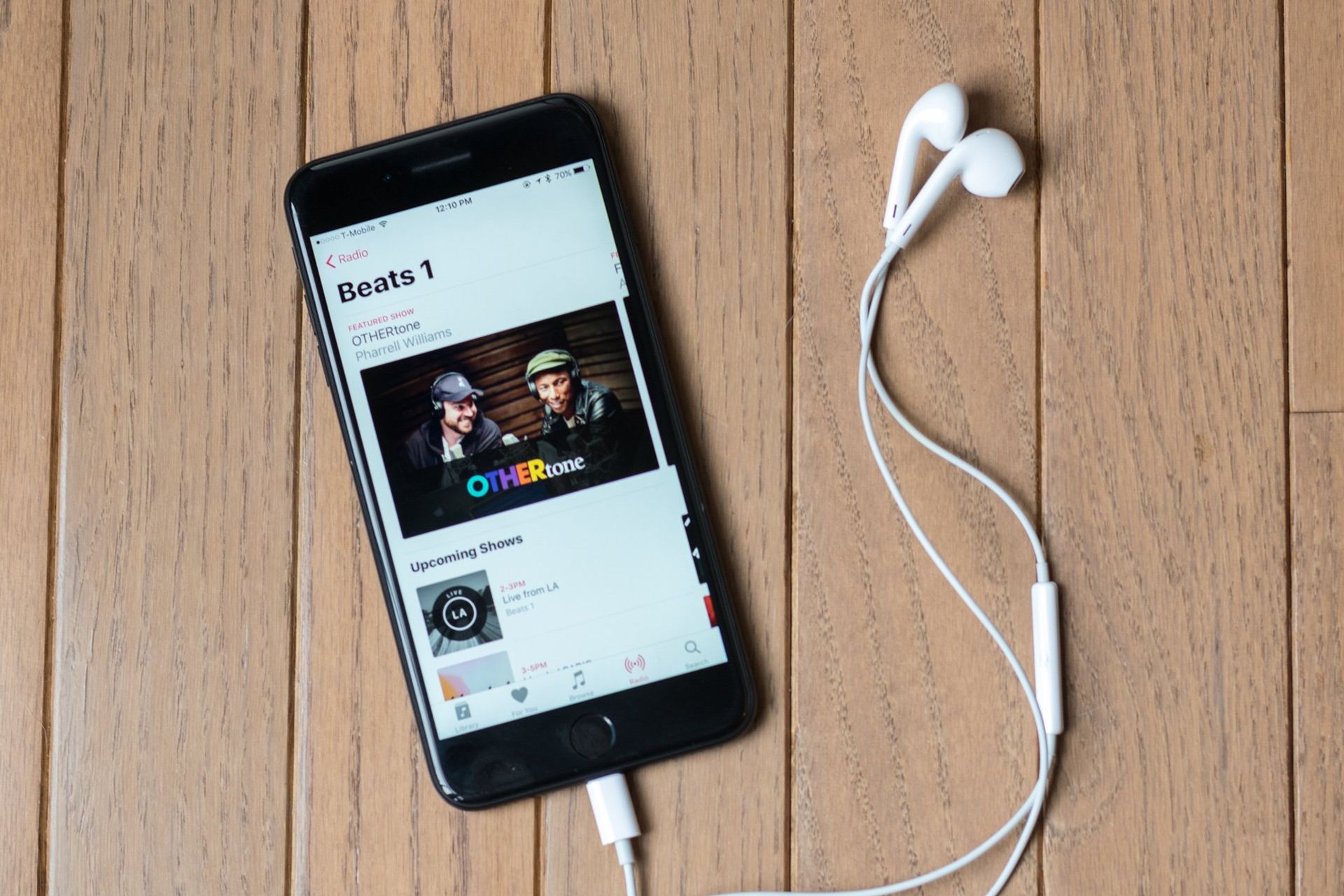 هندزفری متصل شده به گوشی آیفون با پس زمینه چوبی