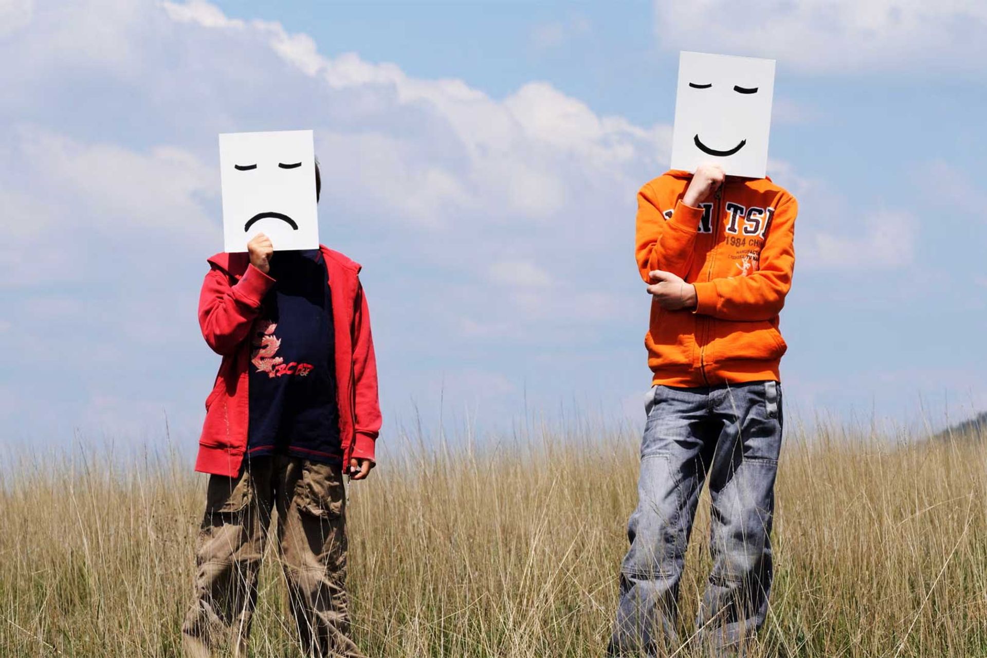 دو انسان بالغ روبروی دوربین ایستاده و ماسک خوشحال و ناراحت به صورت زده‌اند