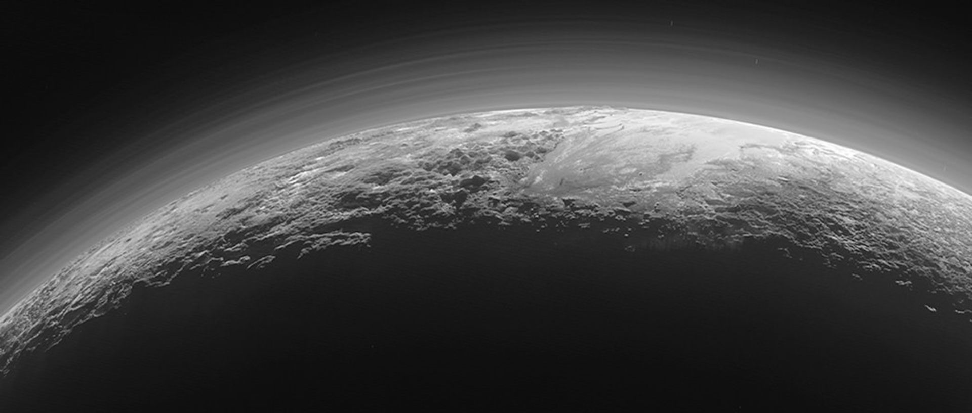 Pluto's atmospheric dust over its rugged mountains and icy plains