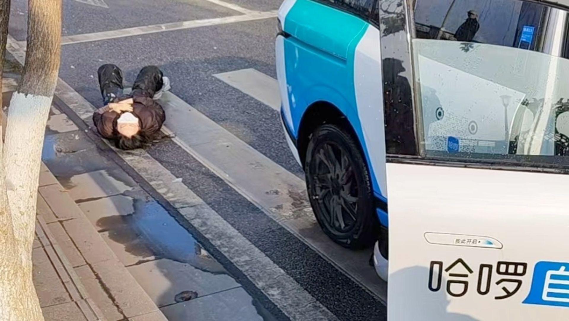 یک نفر روی زمین افتاده کنار خودرو