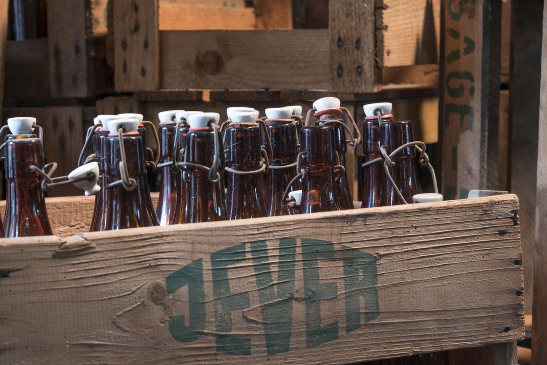 بطری‌های قدیمی قهوه‌ای در باکس چوبی