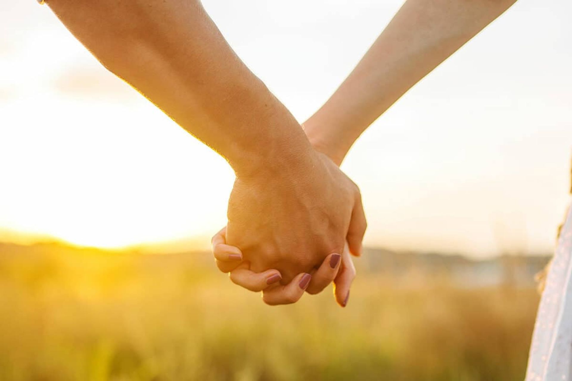 تصویری از نمای نزدیک دستان زن و مردی که دست یکدیگر را گرفته‌اند