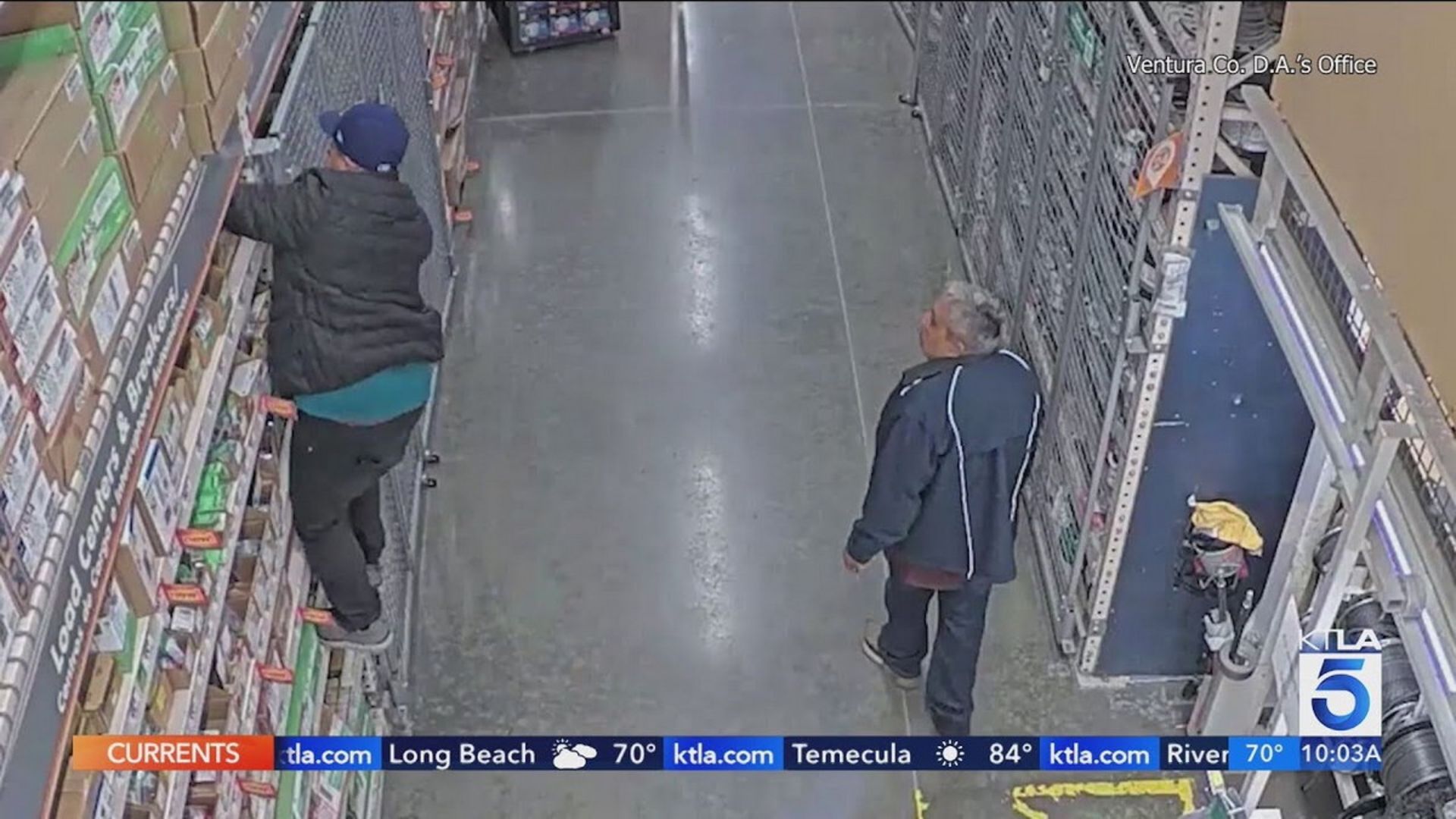 مردی برای دزدی از قفسه فروشگاه بالا می‌رود