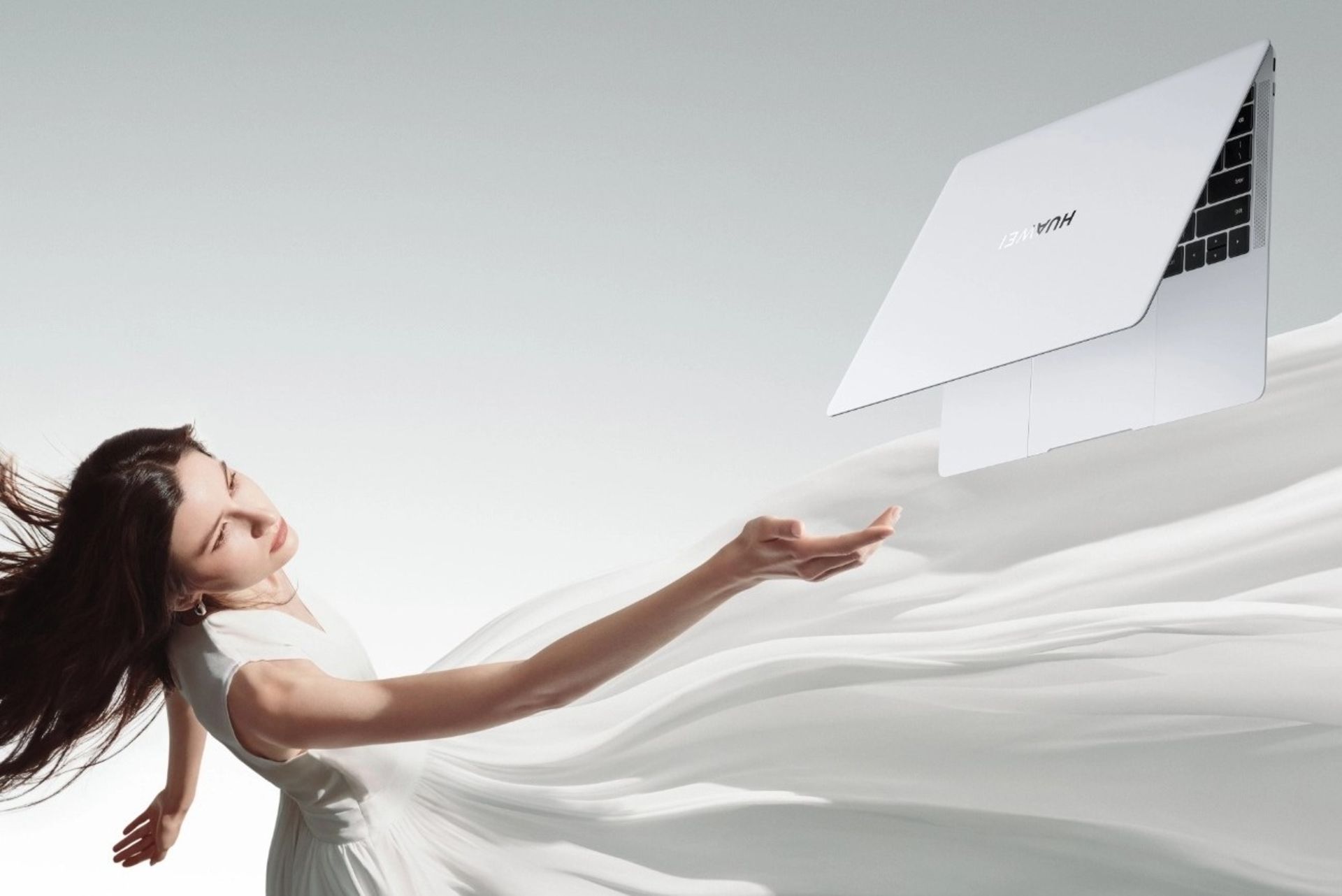 زن در کنار لپ تاپ هواوی میت بوک ایکس پرو ۲۰۲۴