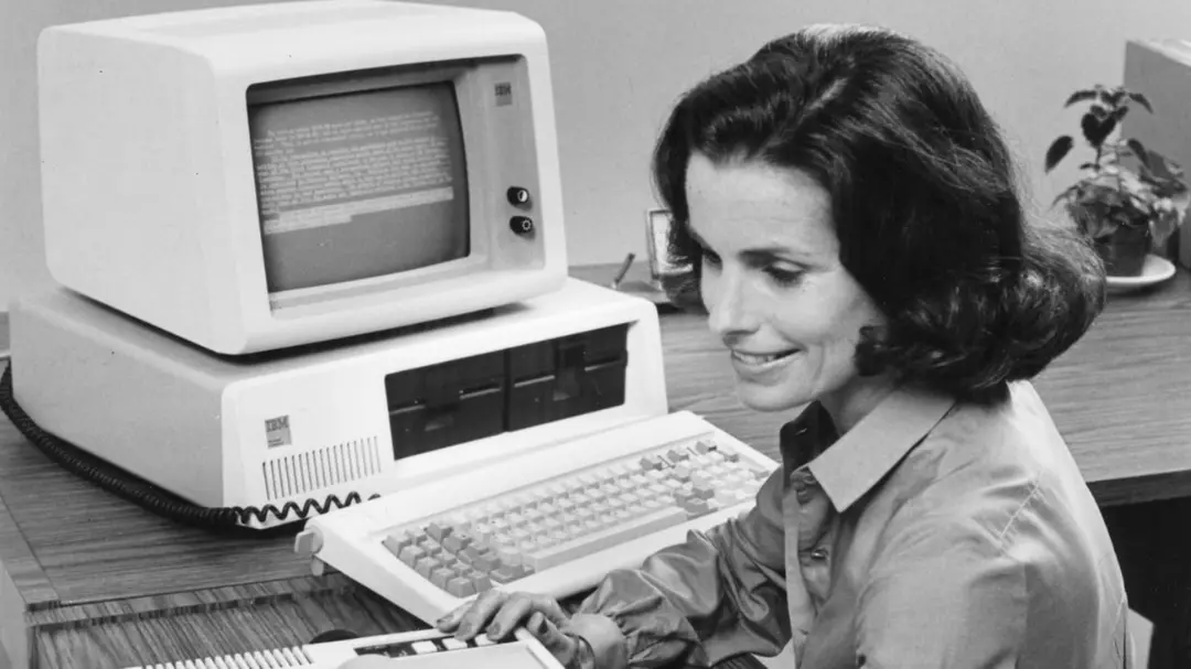 کامپیوتر IBM PC در کنار یک کاربر زن در محیط اداری