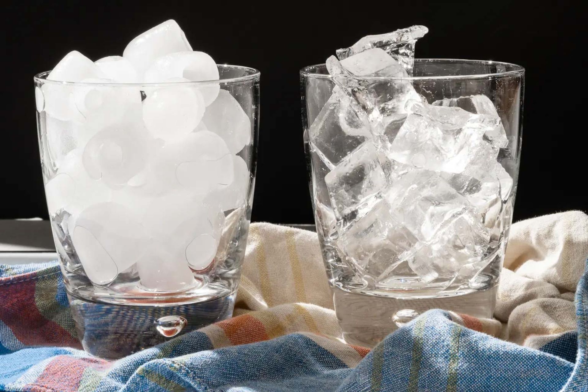 دو لیوان شیشه‌ای پر از یخ‌های کوچک