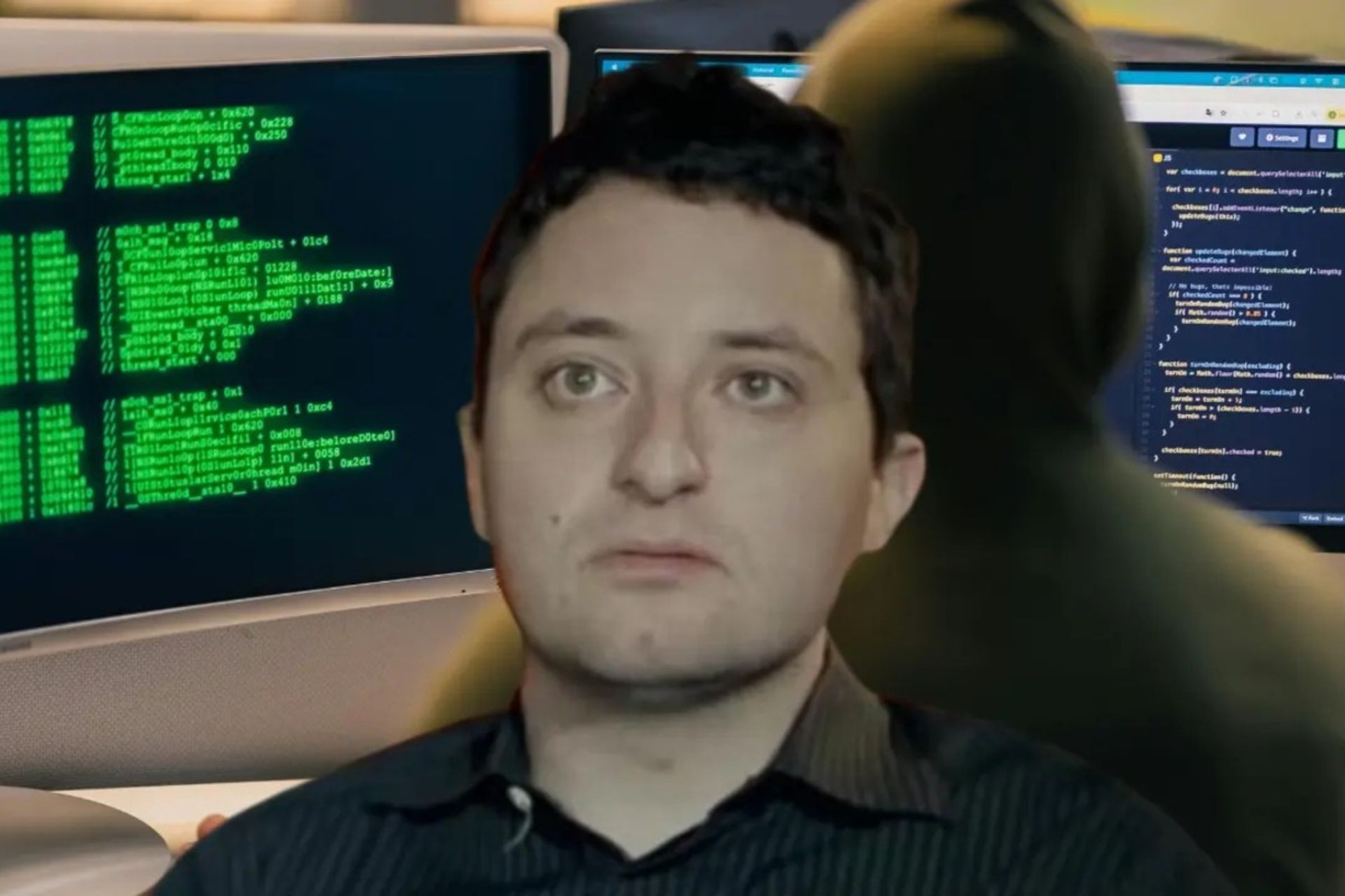 یک مرد جوان جلو یک مانیتور با کدهای سبز