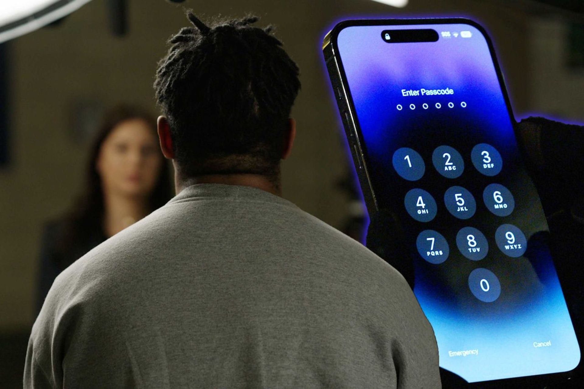 یک مرد در مقابل یک زن با تصویر یک آیفون پشت سرش