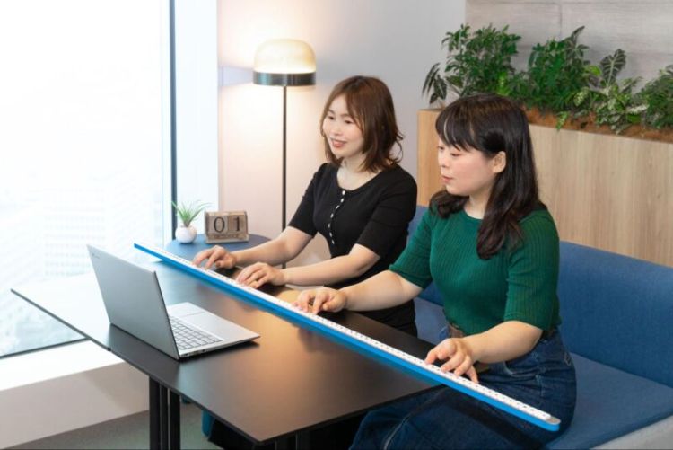 دو ژاپنی در حال تایپ با کیبورد تک‌ردیفه‌ی Gboard Stick Version