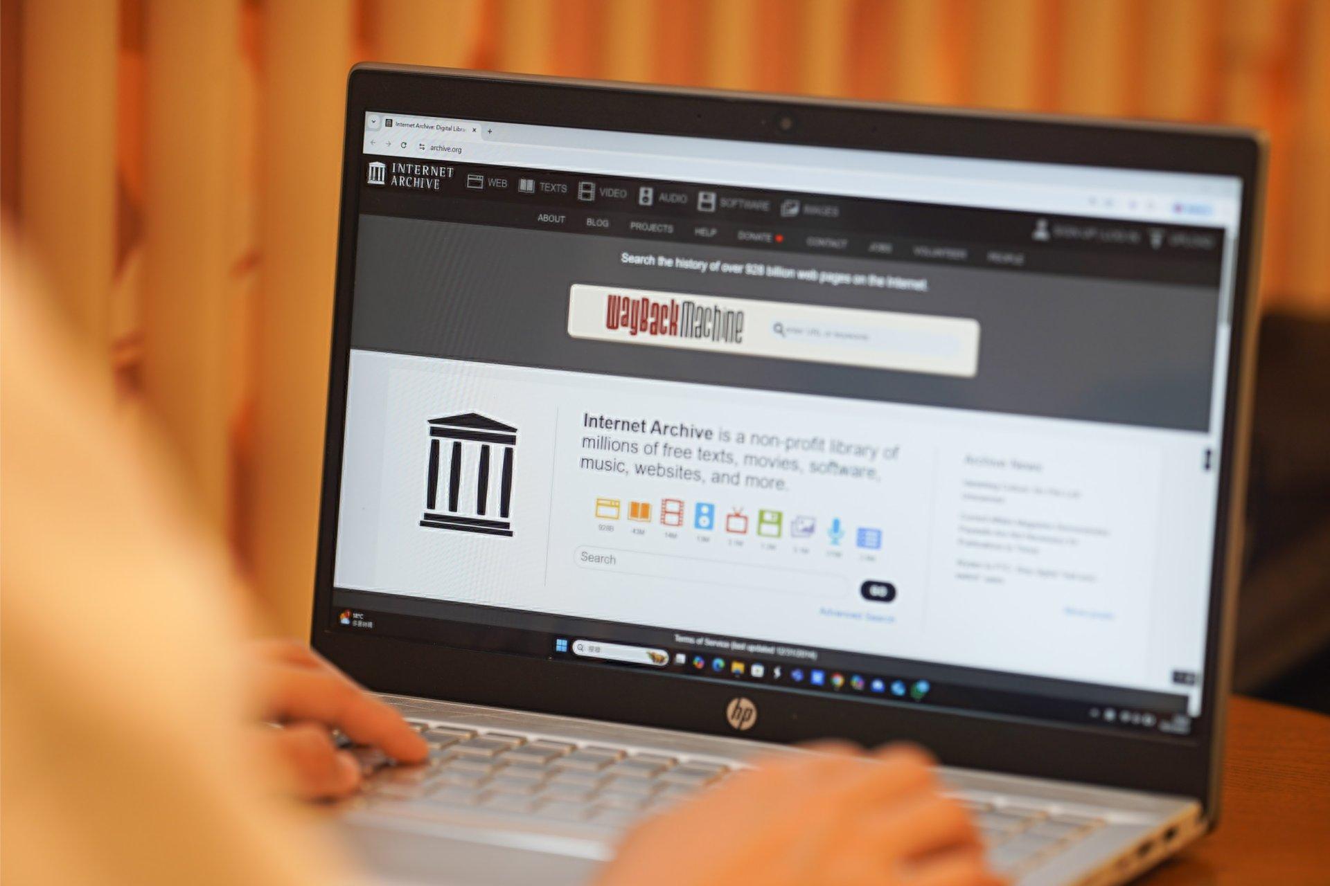 کاربر درحال کار با وب سایت Internet Archive روی لپ تاپ
