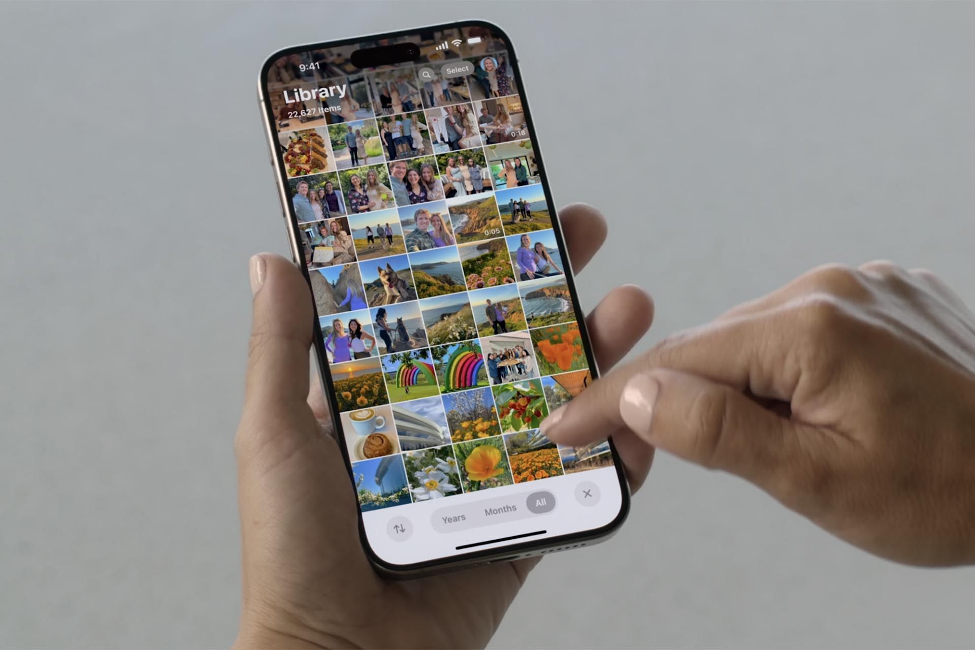 یک گوشی آيفون  با جدول تصاویر اپلیکیشن Photos - همراه با فیلتر ماه و سال در پایین صفحه در دست یک نفر