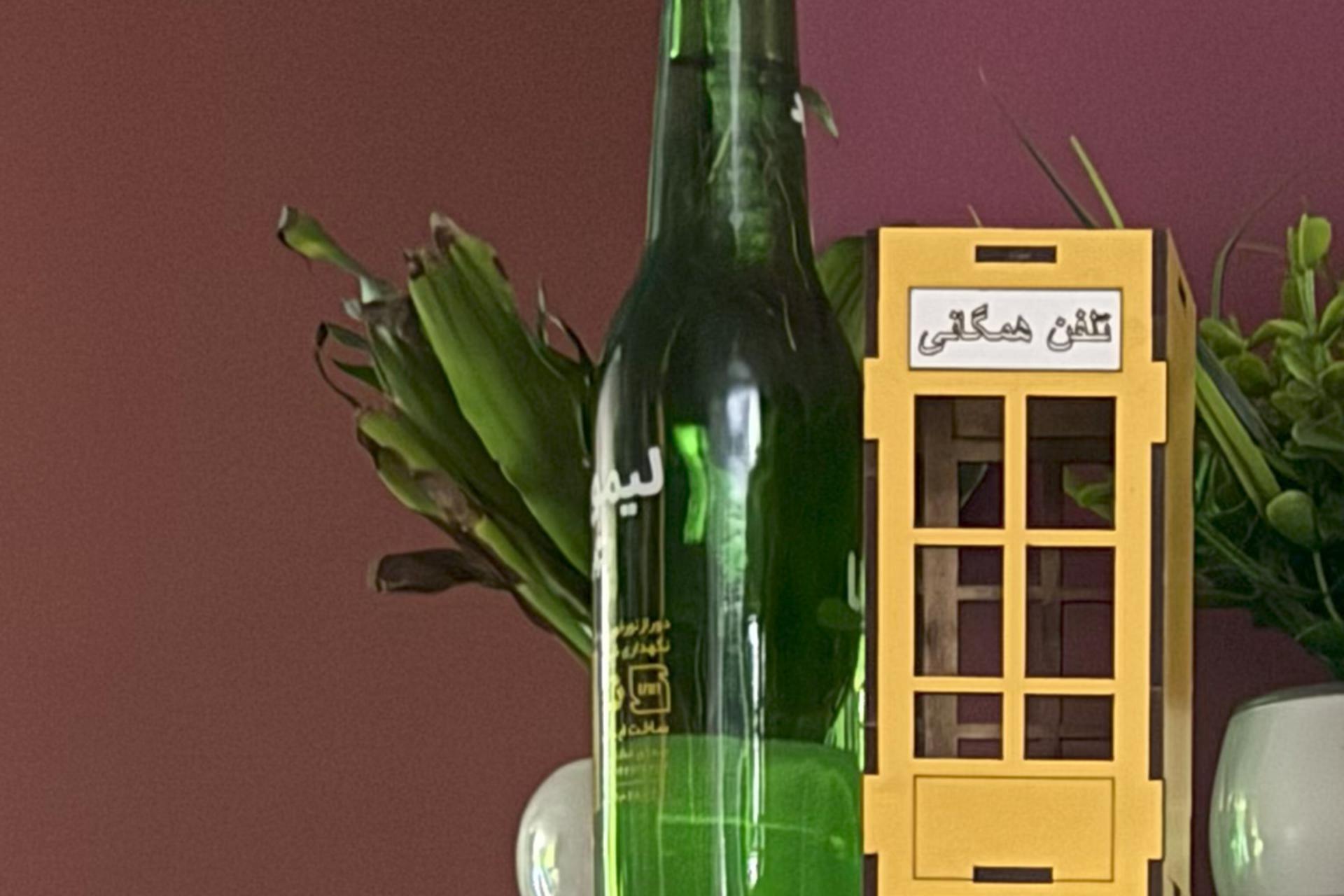 نمونه عکس آیفون ۱۶ پرو مکس از یک باجه تلفن مینیاتوری زرد 