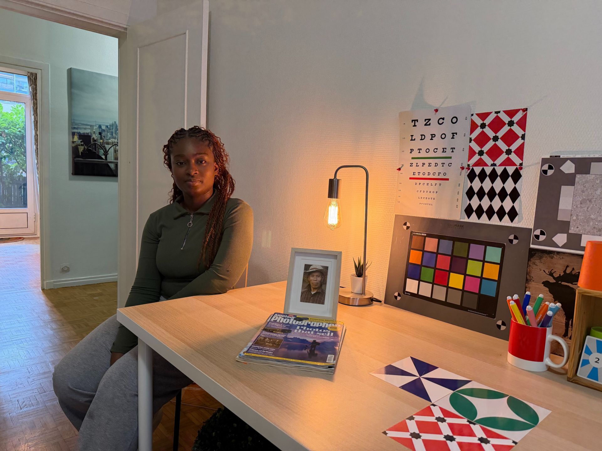 یک زن جوان نشسته کنار میز سفید و نور گرم ملایم