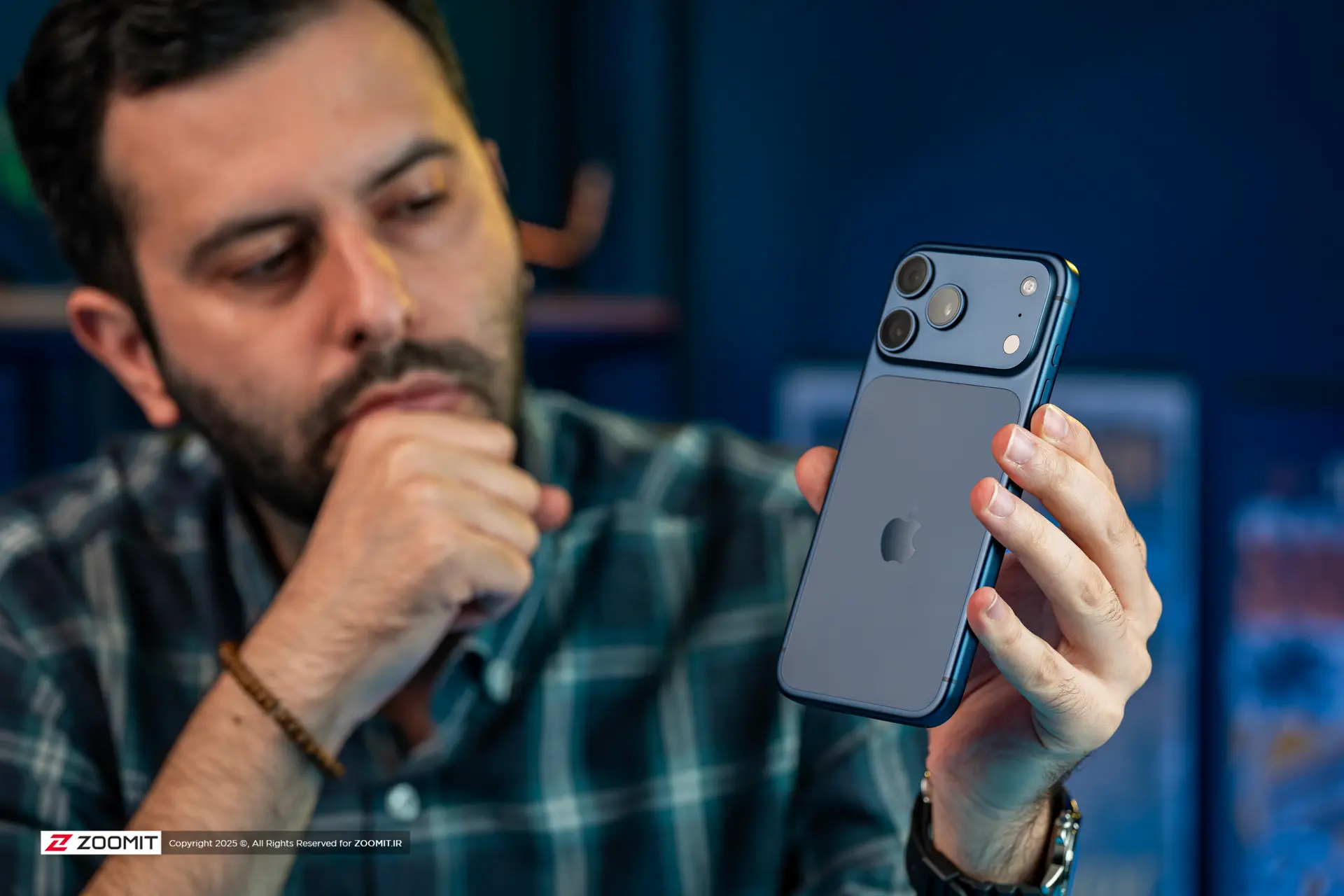 پسر جوان در حال تماشای آیفون ۱۷ پرو مکس / iPhone 17 Pro Max
