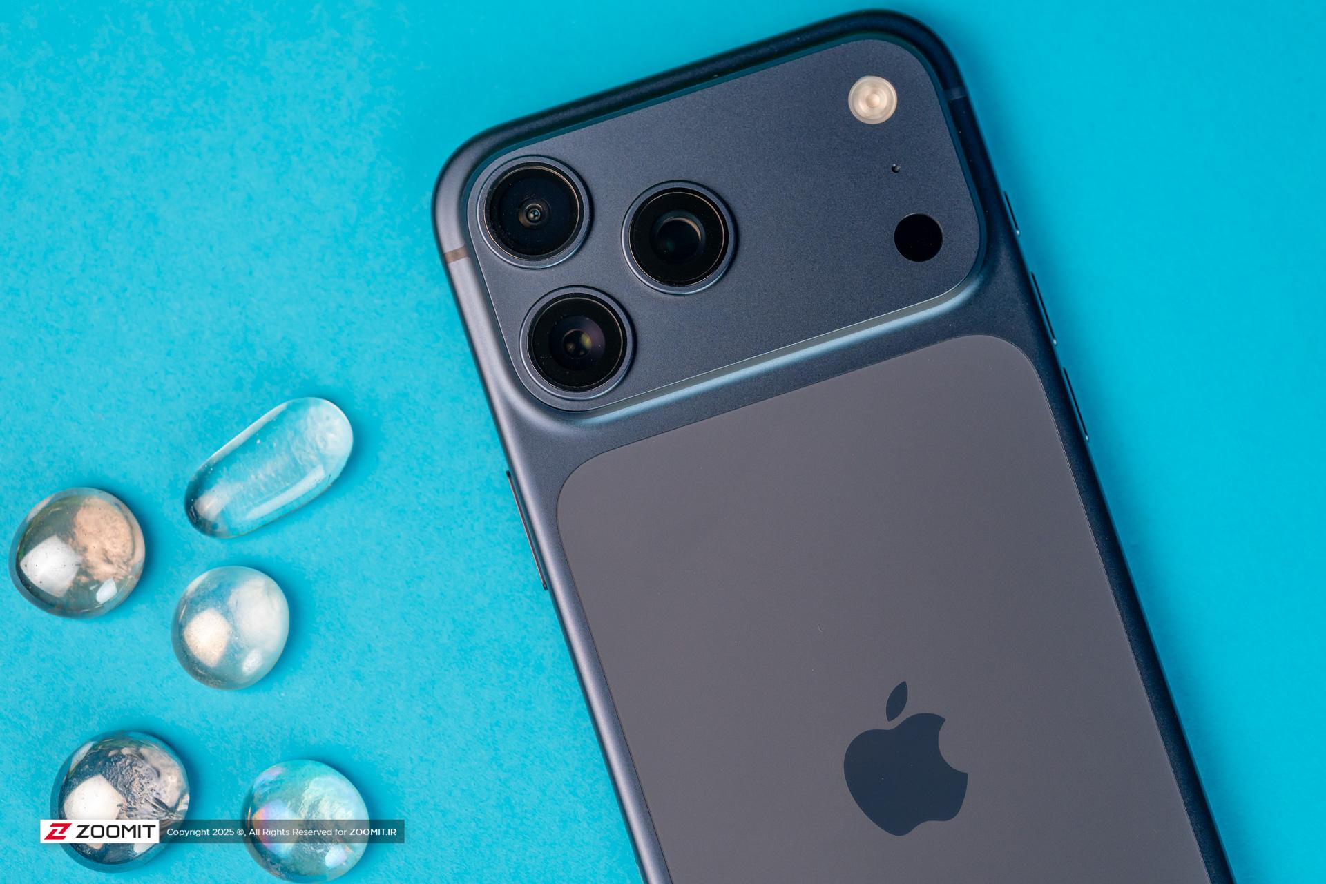 آیفون ۱۷ پرو مکس / iPhone 17 Pro Max در کنار قطرات آب پس زمینه آبی