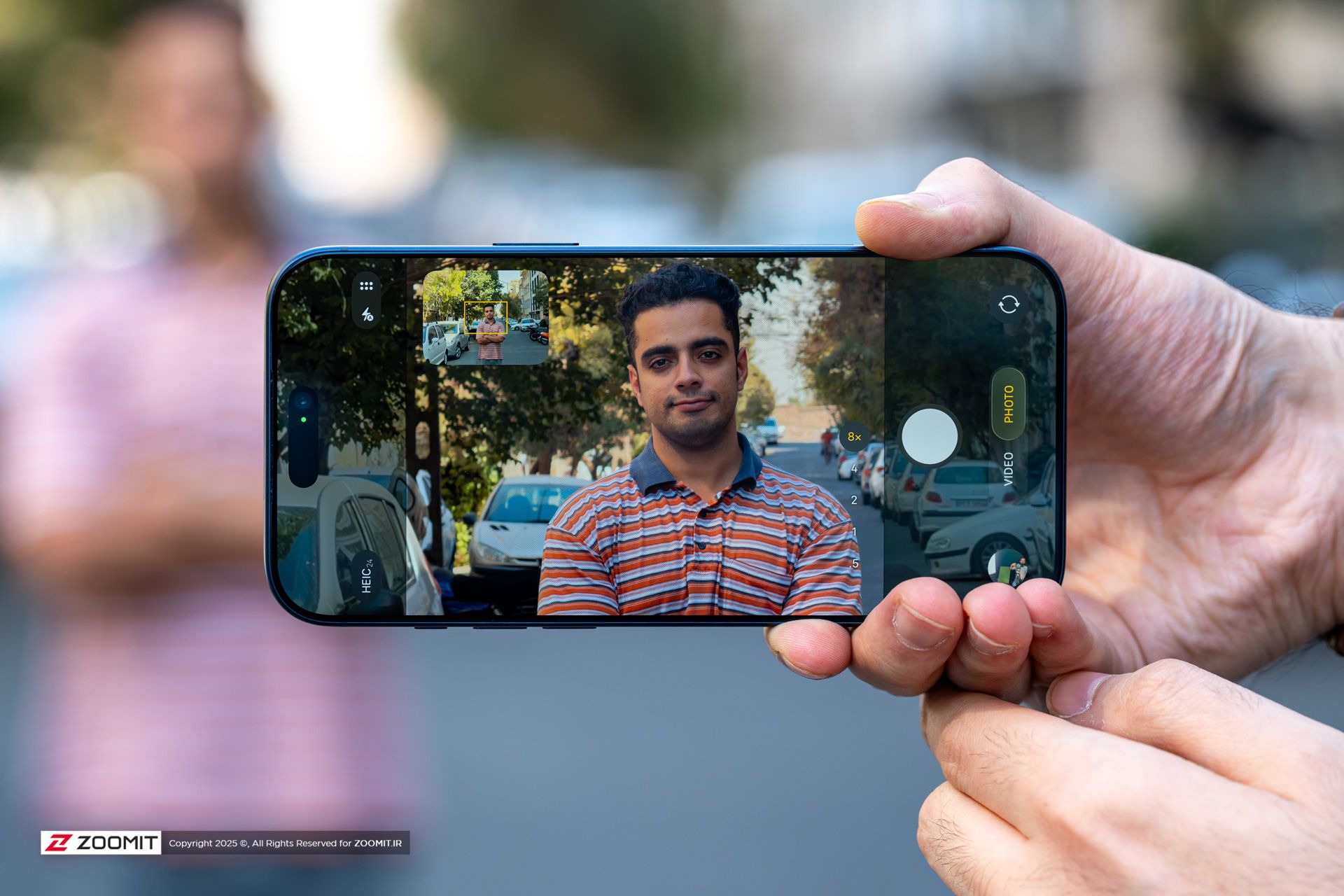 عکس پسر جوان با لباس خط خط در صفحه گوشی آیفون ۱۷ پرو مکس / iPhone 17 Pro Max