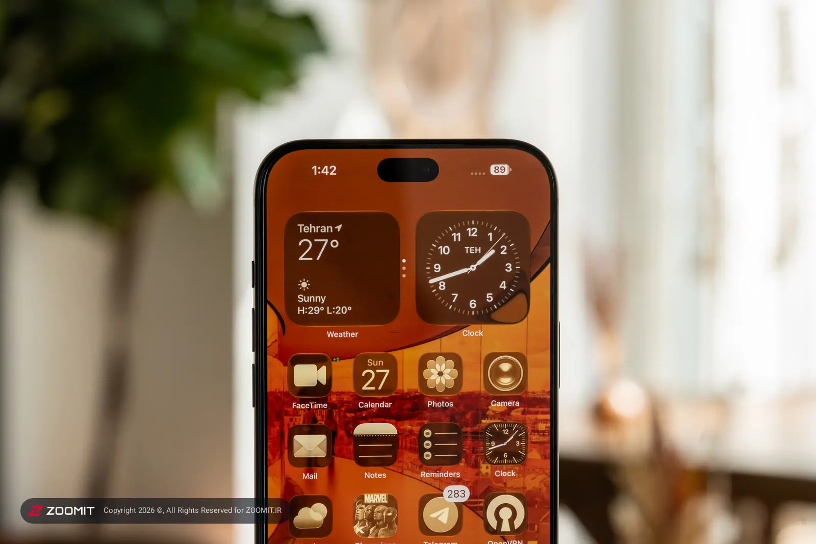 نمای نزدیک صفحه نمایش گوشی آیفون ۱۸ پرو مکس (iPhone 18 Pro Max) با ویجت‌های ساعت و آب‌وهوا
