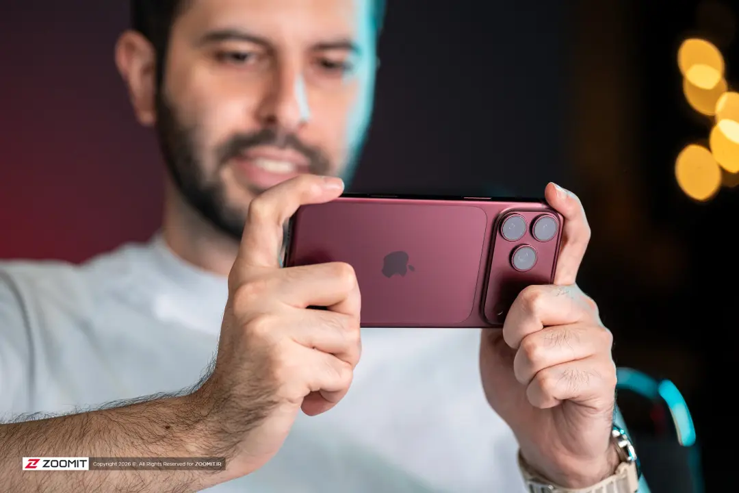 گوشی آیفون ۱۸ پرو مکس (iPhone 18 Pro Max) با رنگ زرشکی در دست کاربر