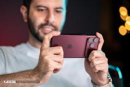 گوشی آیفون ۱۸ پرو مکس (iPhone 18 Pro Max) با رنگ زرشکی در دست کاربر