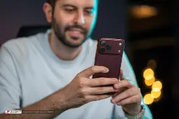گوشی آیفون ۱۸ پرو مکس (iPhone 18 Pro Max) با رنگ زرشکی در دست مرد