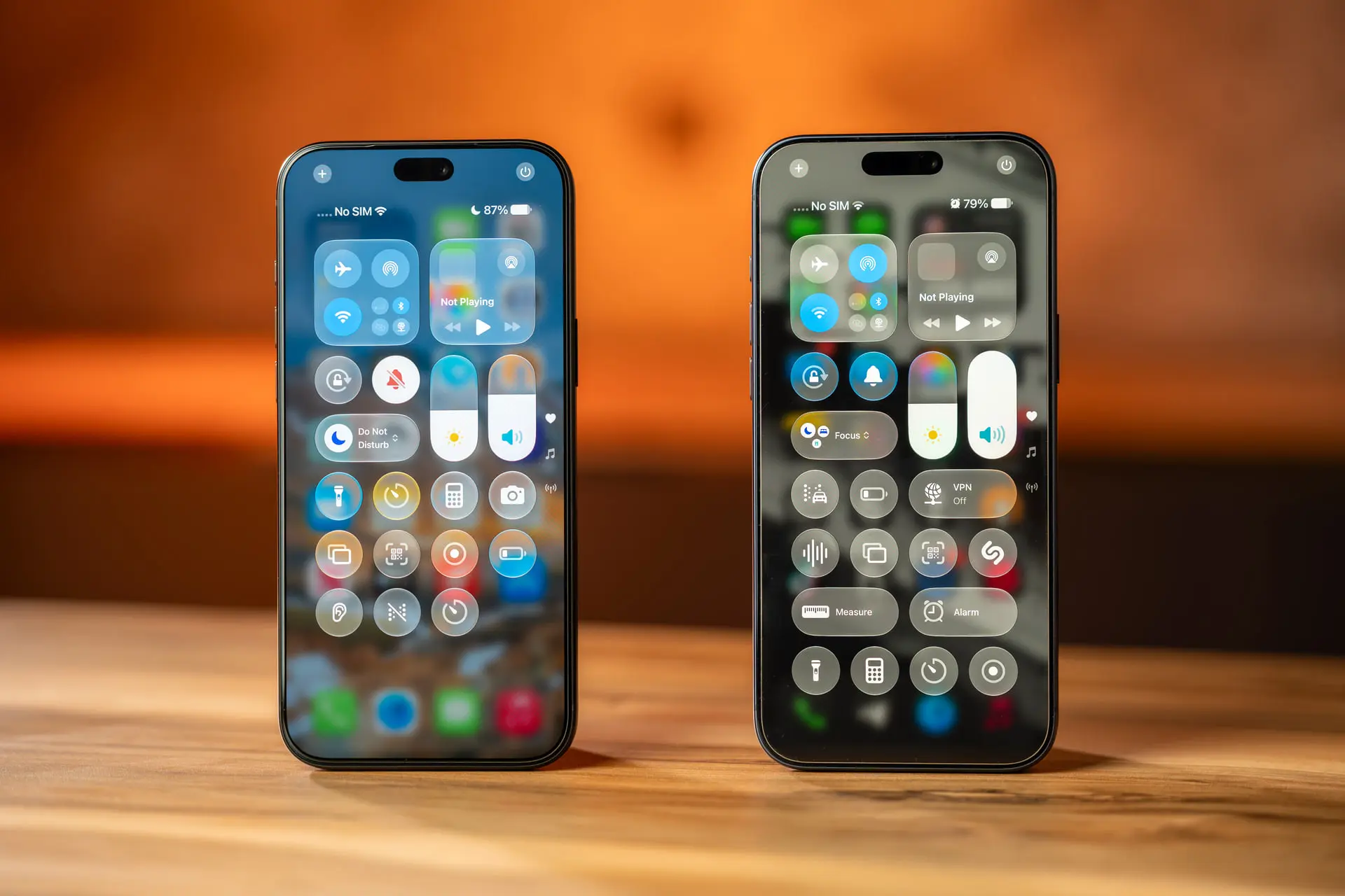 دو گوشی آیفون ۱۸ پرو مکس (iPhone 18 Pro Max) با رابط کاربری متفاوت روی میز چوبی