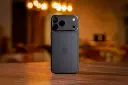 گوشی آیفون ۱۸ پرو مکس (iPhone 18 Pro Max) با بدنه تیره روی میز چوبی