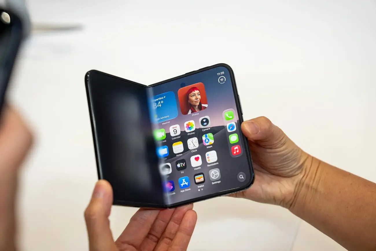 گوشی تاشو آیفون دوئو (iPhone Duo) در دست دو نفر با نمایشگر خمیده