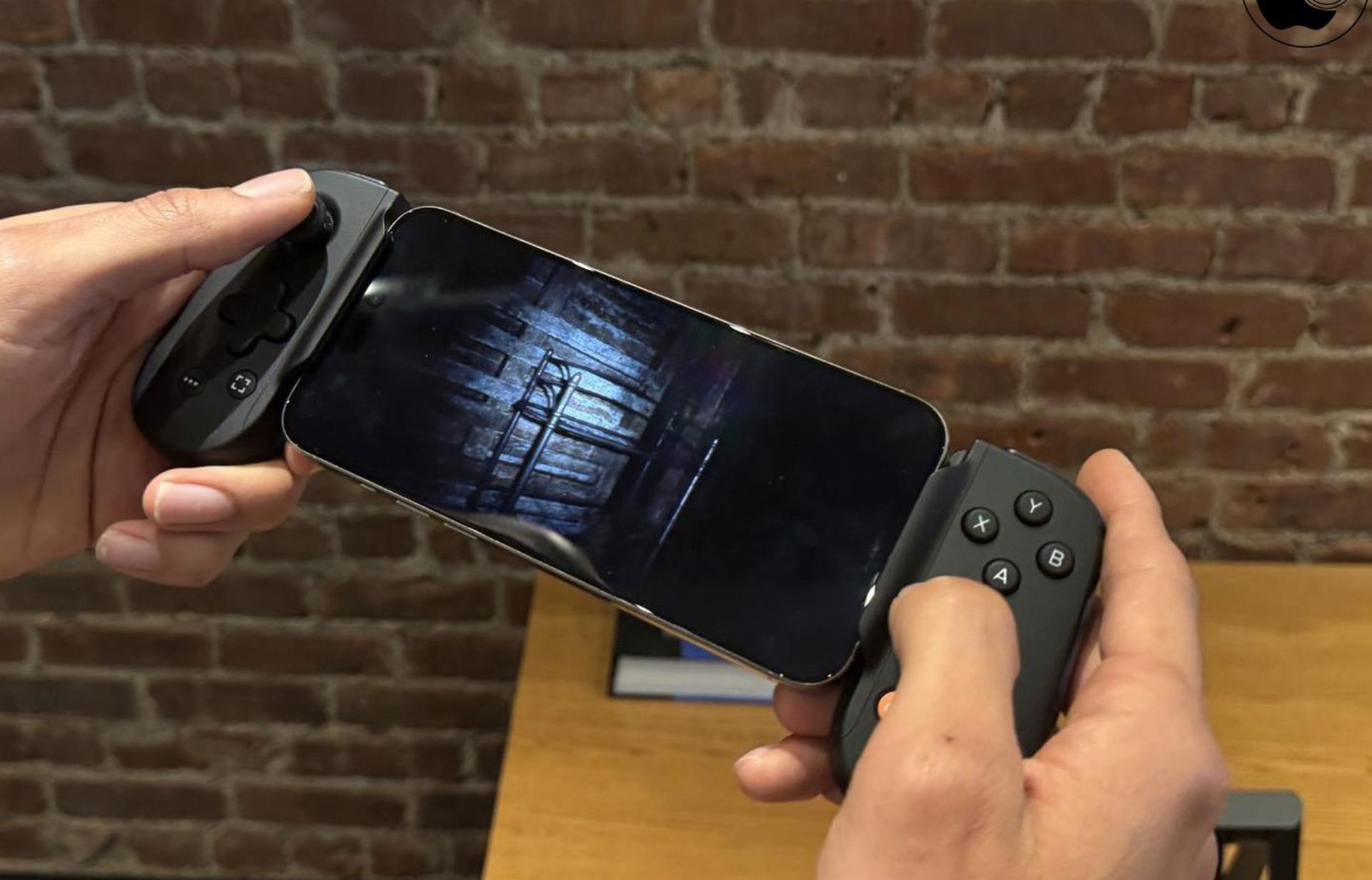 آیفون به همراه دسته بازی درحال اجرای بازی دردست کاربر