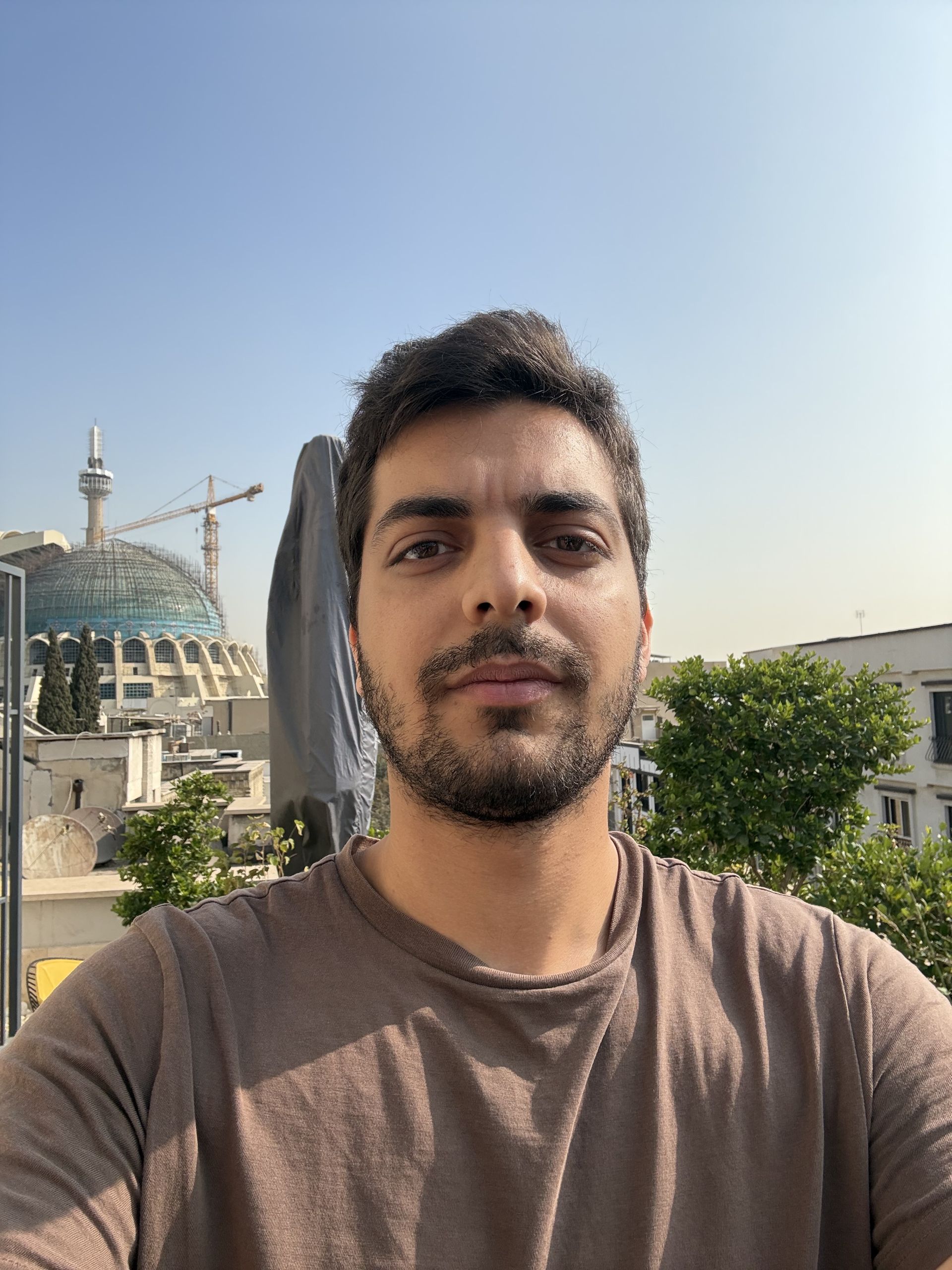 نمونه عکس سلفی آیفون ۱۶ در فضای باز با پس‌زمینه گنبد مسجد