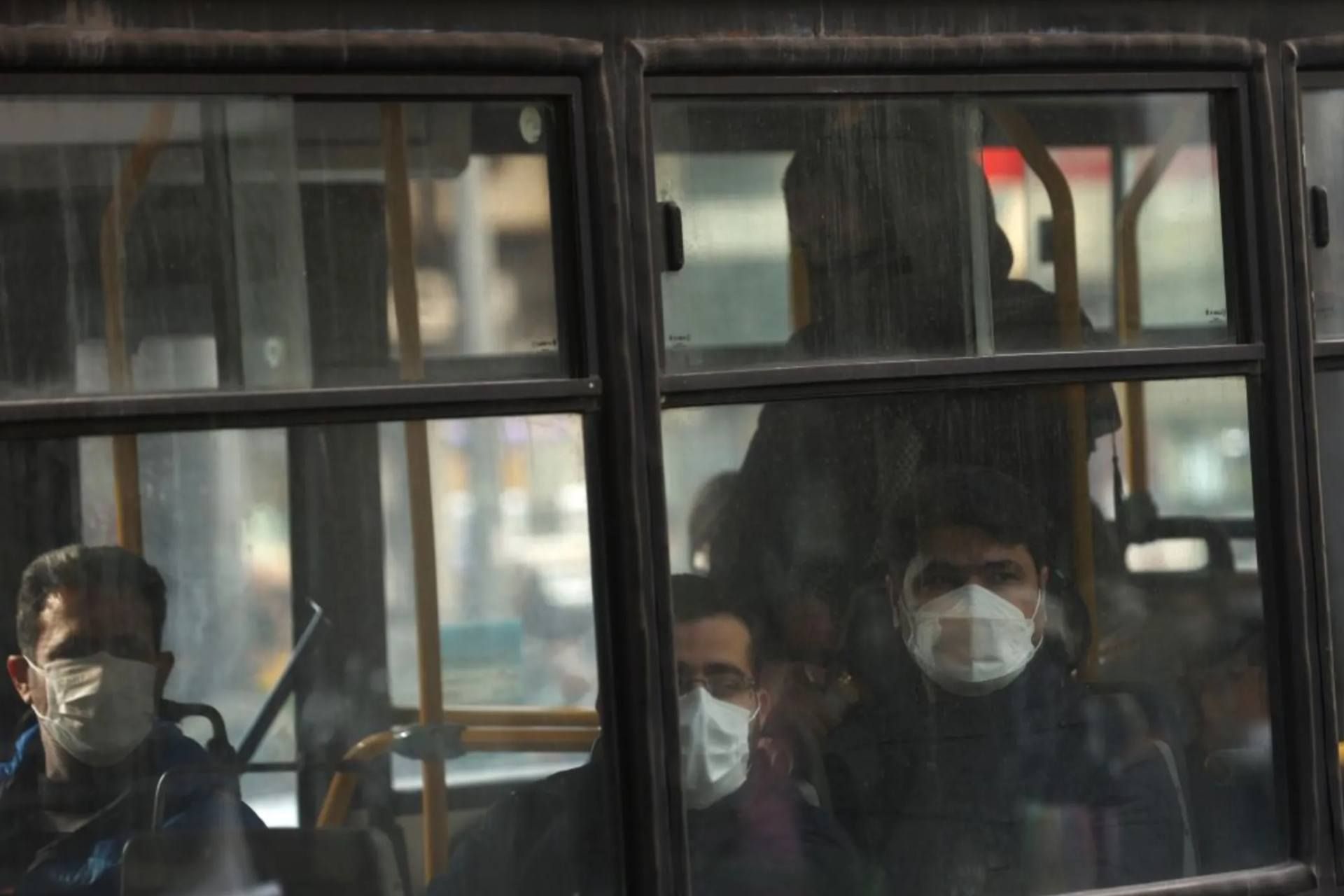 چند نفر با ماسک در اتوبوس در هوای آلوده