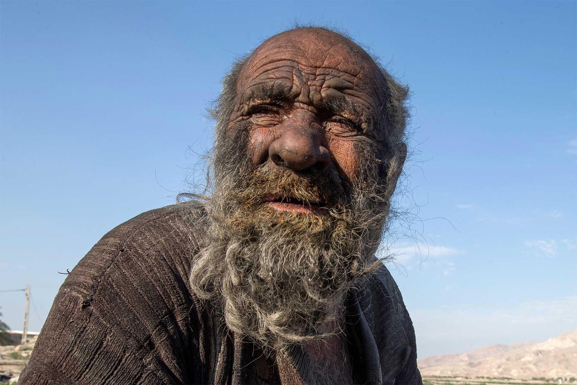 چهره دوده‌گرفته شخصی کهنسال با ریش‌های بلند